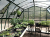Spacious Grandio greenhouse with open double doors and vibrant potted flowers on display.